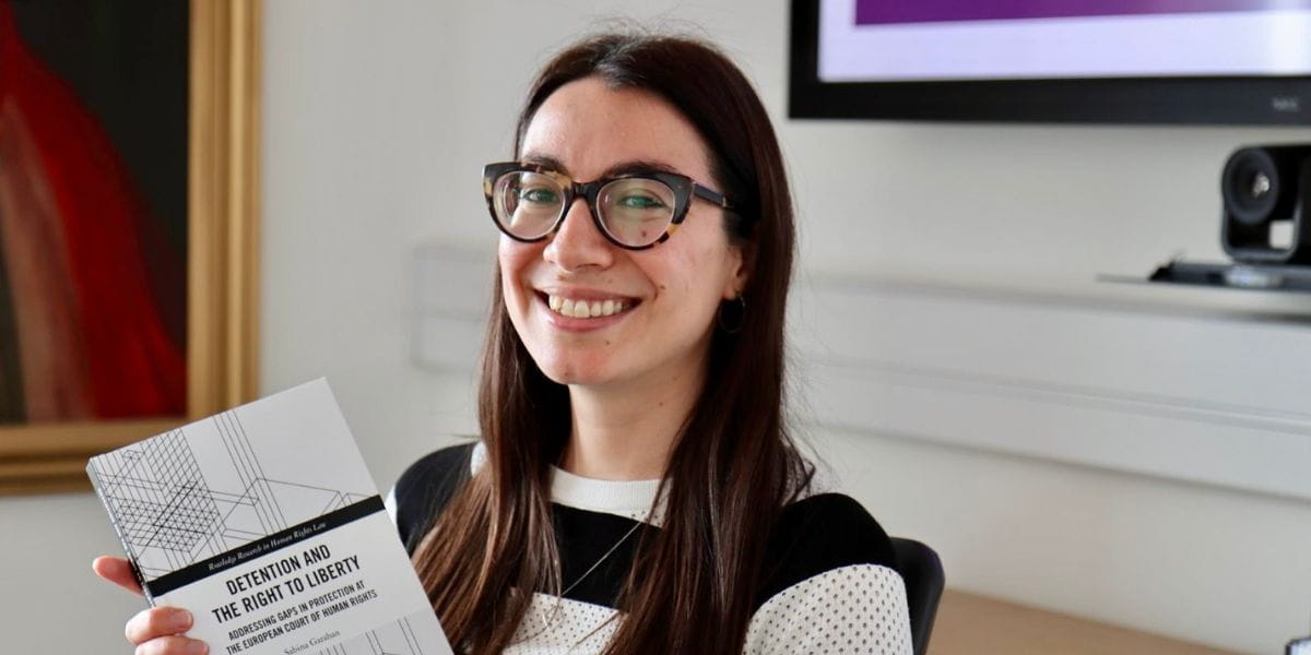 Sabina Garahan holding a copy of the book Detention and the Right to Liberty: Addressing Gaps in Protection at the European Court of Human Rights at a book launch event.