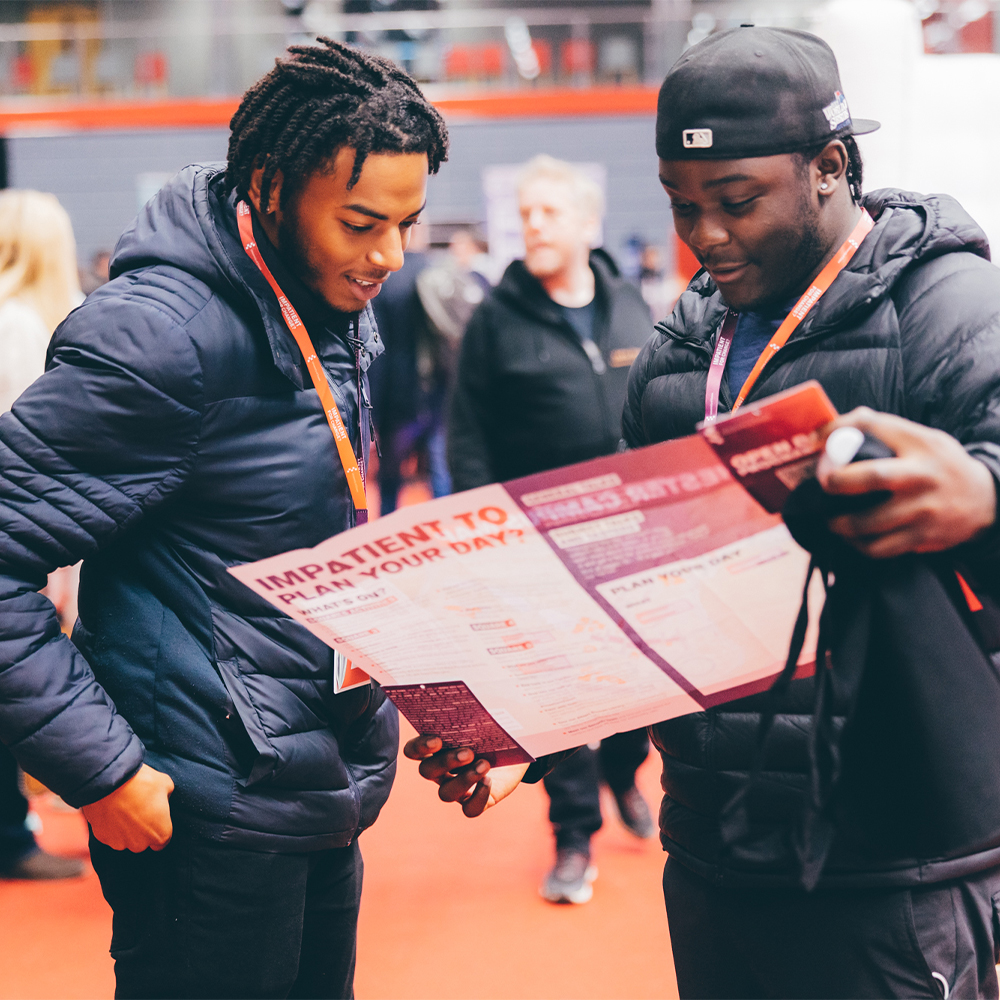 Two male visitors looking at an event programme at an open day.