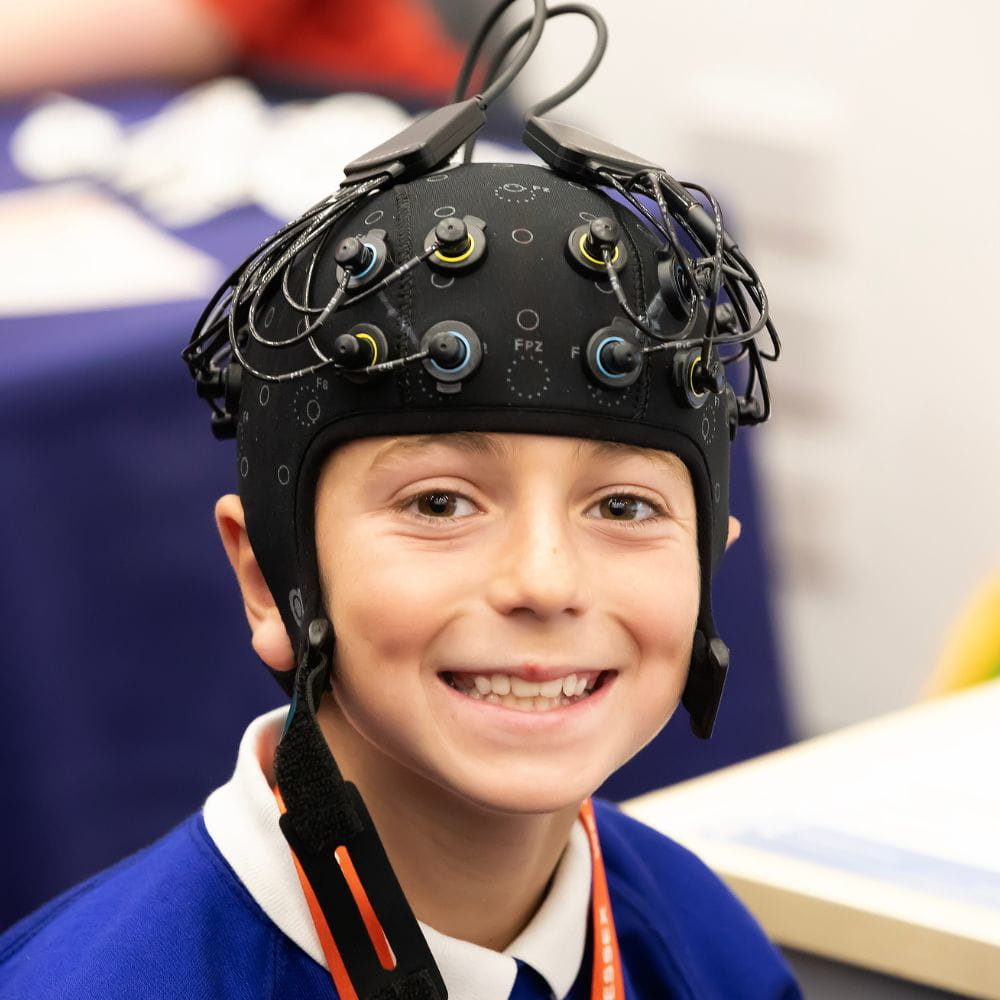 A smiling child in a FNIRS cap