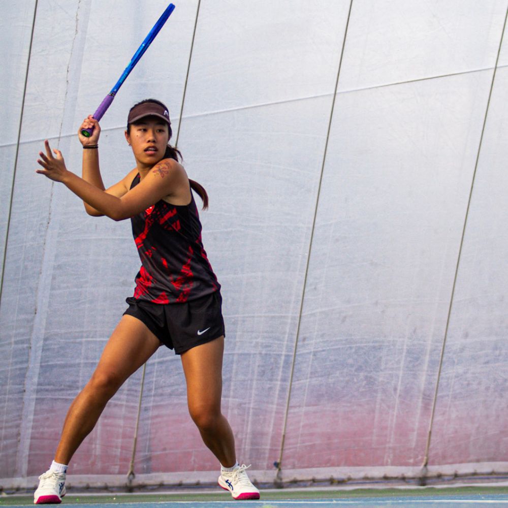 Abby Fung hits a forehand in the Colchester Campus' tennis dome 