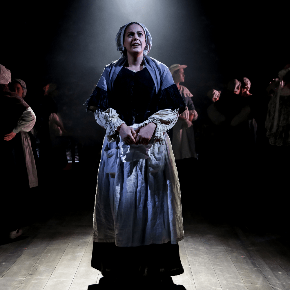 a person dressed in costume on a dark stage