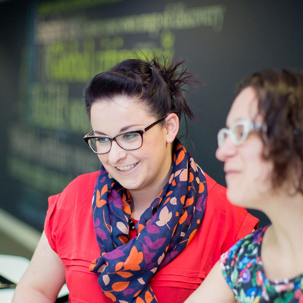 Female colleague wearing glasses giving support at a computer
